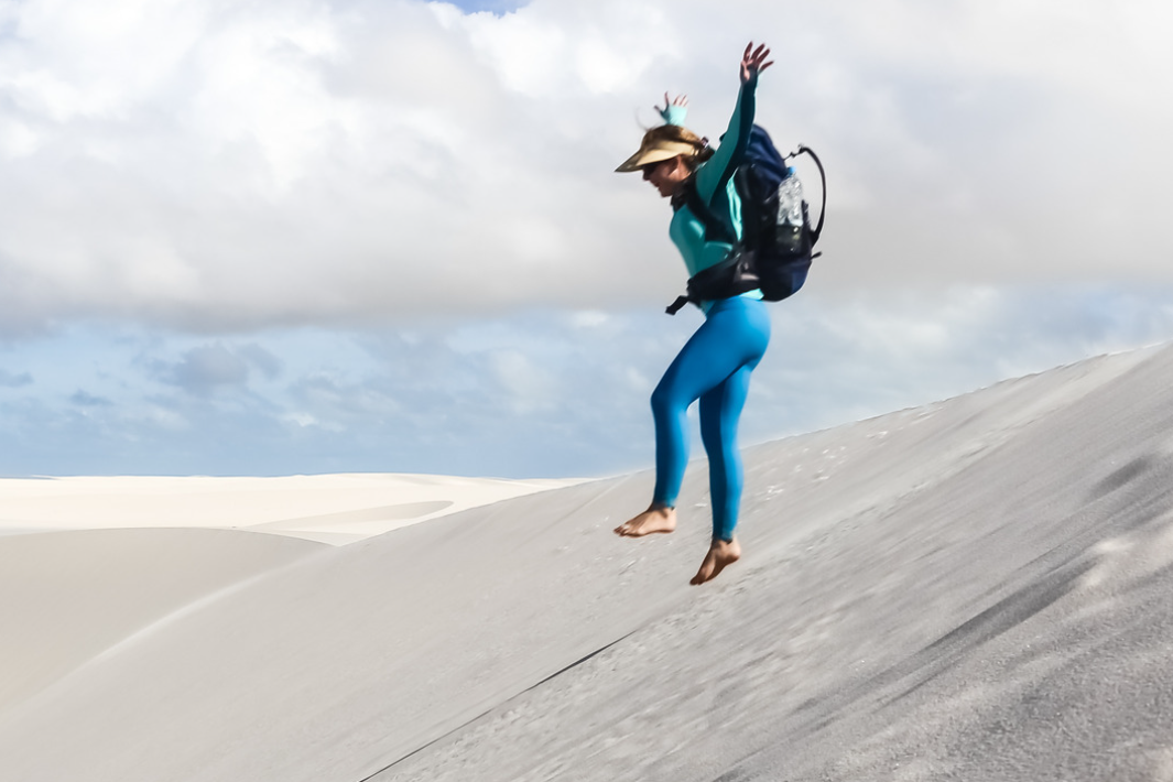 Mulher pulando em uma duna dos Lençóis Maranhenses